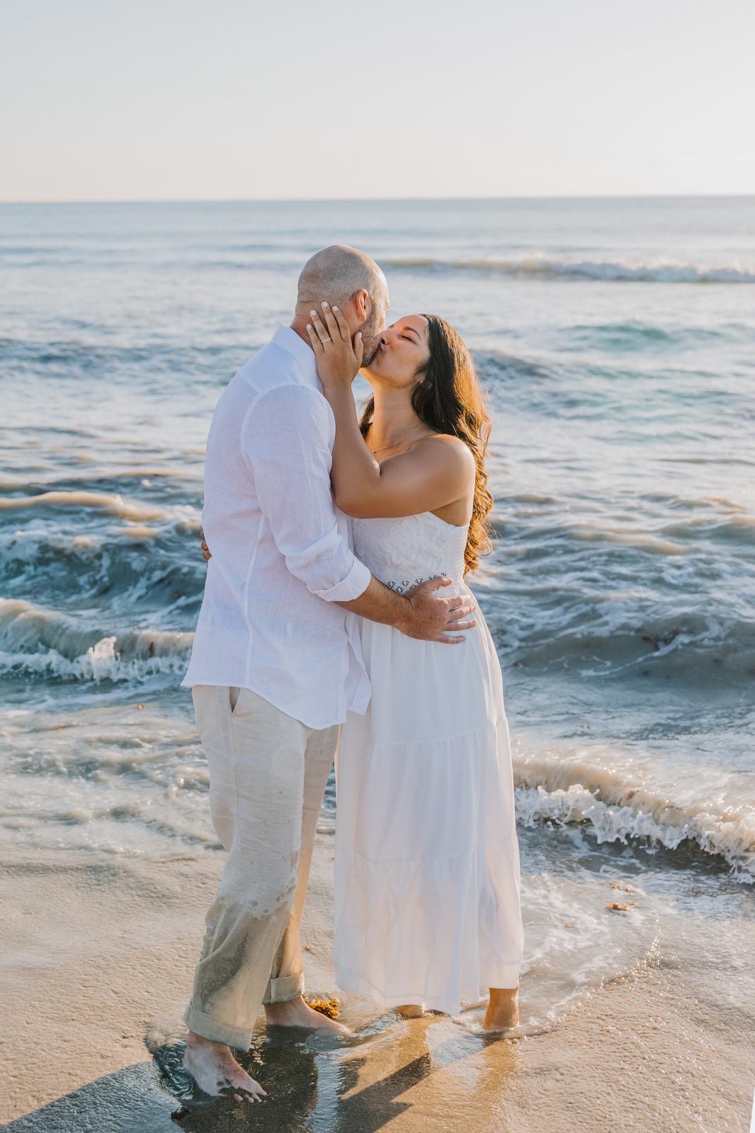 Couple kissing in the surf at golden hour in South Florida